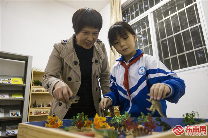老師在心理咨詢室與學生開展沙盤互動游戲。董觀生攝.jpg