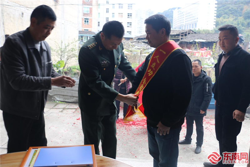 人武部部長為李招軍家屬披戴綬帶。拍攝：陳開獎.png