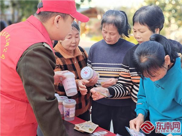 志愿者為旅客發種子  張秀華.jpg