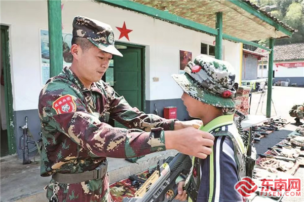 曹水興（左）為參加訓練營的孩子整理著裝，曾程供圖.png