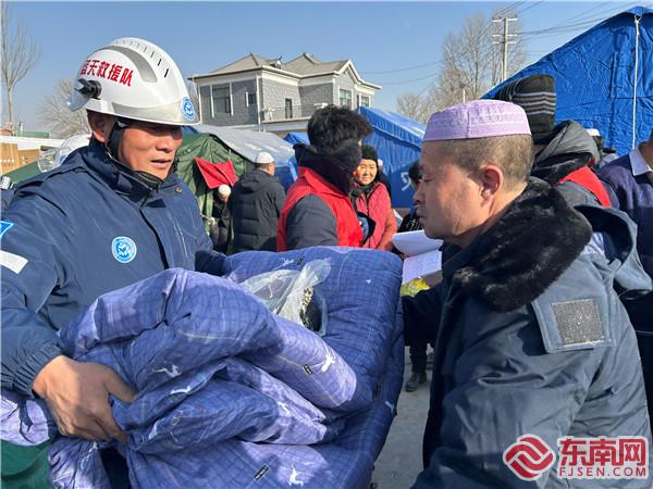 圖為建寧法院干警龍森懷為受災群眾發放救災物資.jpg