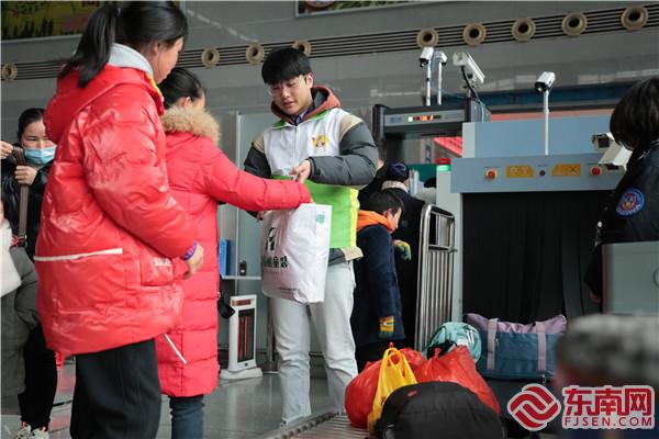 在建寧縣北站，鐵路青年志愿者正在幫助旅客提行李。 張海根 攝.jpg