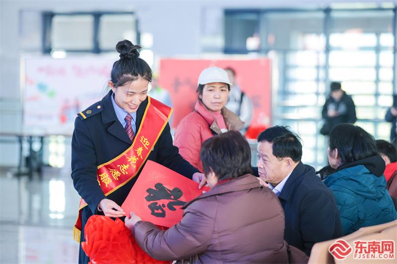 2025年1月14日，永安南站迎春花服務臺人員為旅客送上手寫春聯。 張海根 攝.jpg