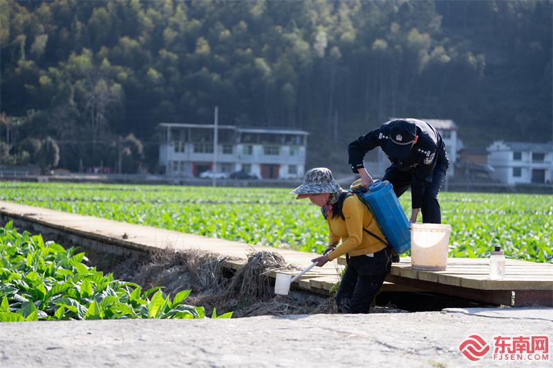 圖為3月20日，民警協(xié)助煙農播灑化肥.jpg